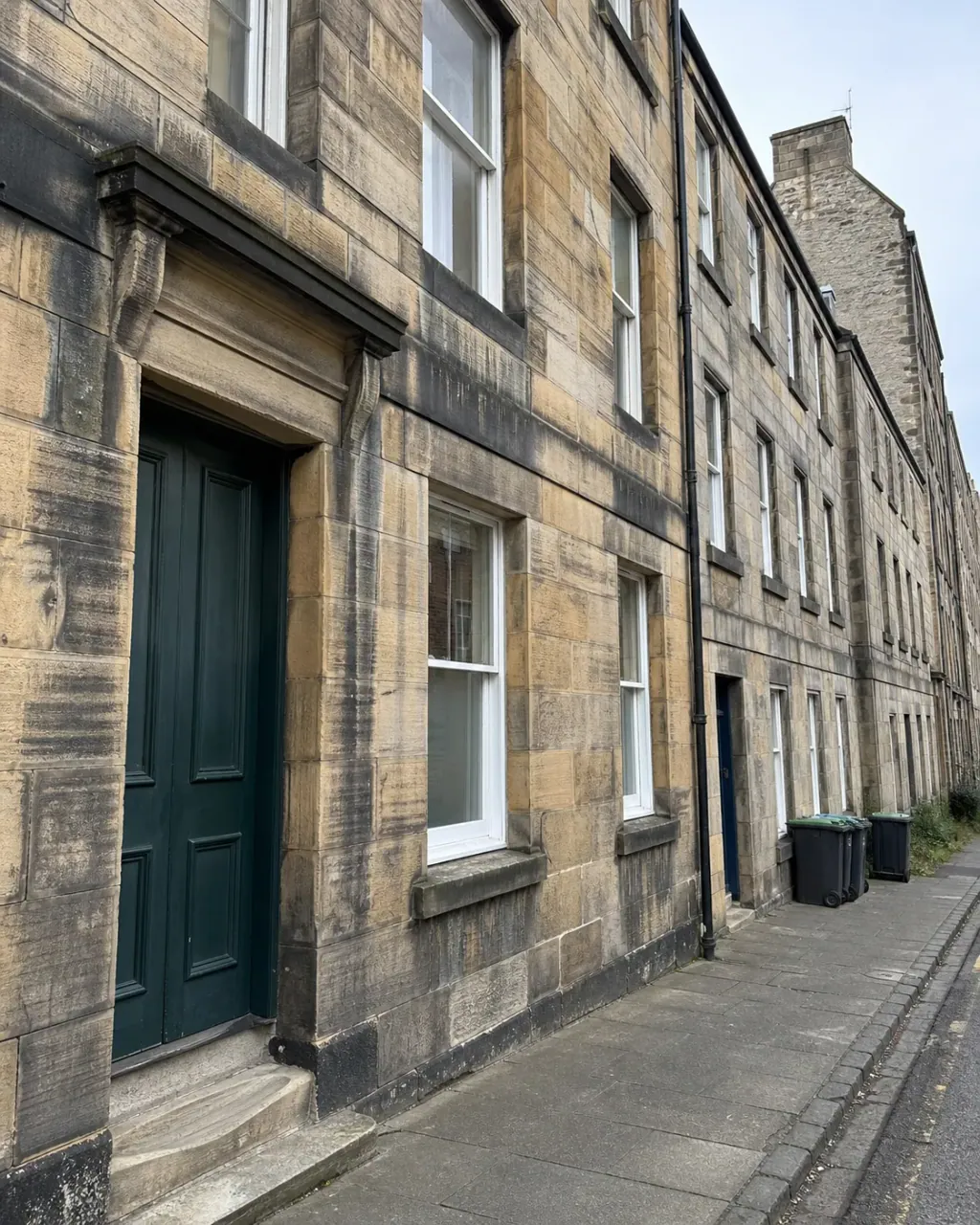 A terrace of stone tenements along a Newington street
