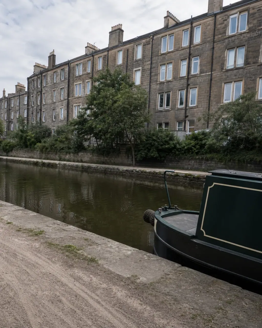 Stone tenements rising behind the Union Canal towpath at Polwarth