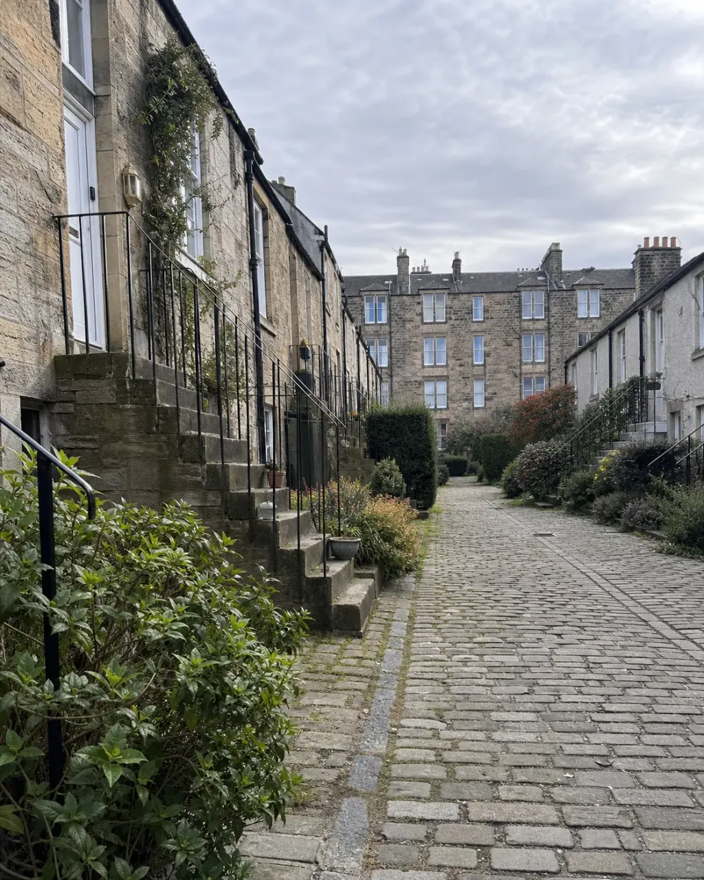 Stone colony houses with outside stairs on a cobbled Stockbridge lane